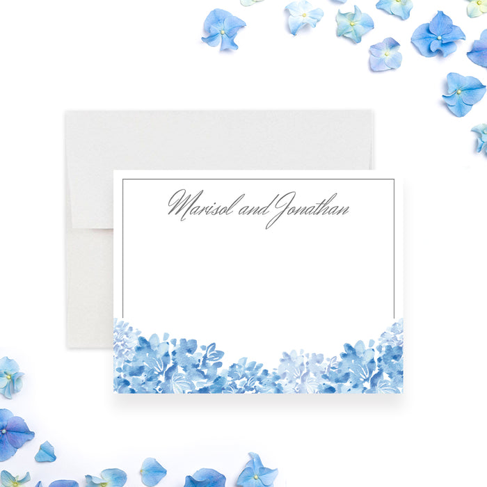 Personalized blue watercolor hydrangea wedding note card with couple’s names in gray script, a thin border, and blue flowers along the bottom-front