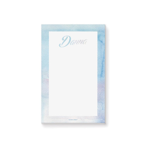 personalized blue watercolor notepad with custom name in script lettering, soft watercolor border, and blank writing space