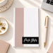 Personalized blush pink and black notepad with a custom name in white script lettering, and a white writing area.