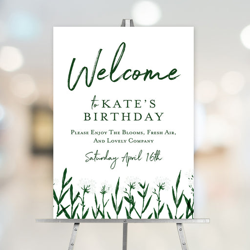 Personalized botanical garden party birthday welcome sign with green wildflowers displayed on an easel