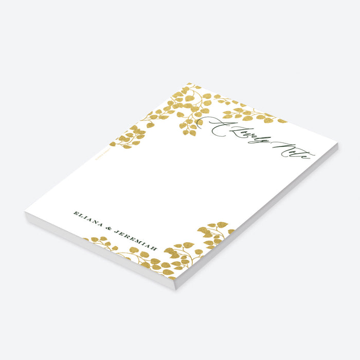 Personalized blank botanical notepad with A Lovely Note wording, gold-colored leaf vines and custom couple’s names-side