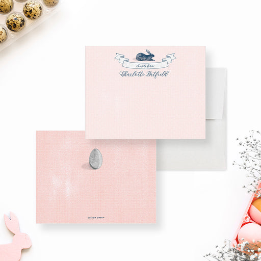 Personalized Bunny and Easter Egg Note Cards. Front and pink patterned back with an illustrated Easter egg shown with a white envelope.