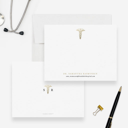 Personalized caduceus note cards with a printed gold medical symbol and name, shown with white envelopes-front-back
