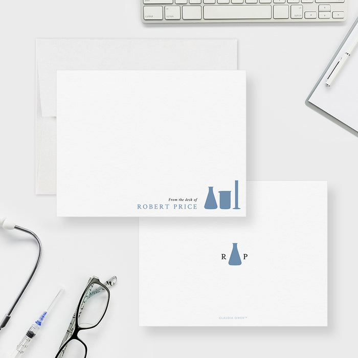Chemistry note cards with blue laboratory glassware and a name on the white front; blue flask and initials on the white back.