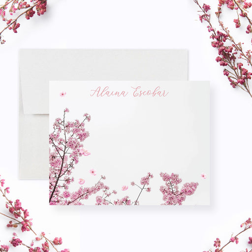 Personalized note card with a white front with pink cherry blossom branches and a personalized script name. Shown with a white envelope.