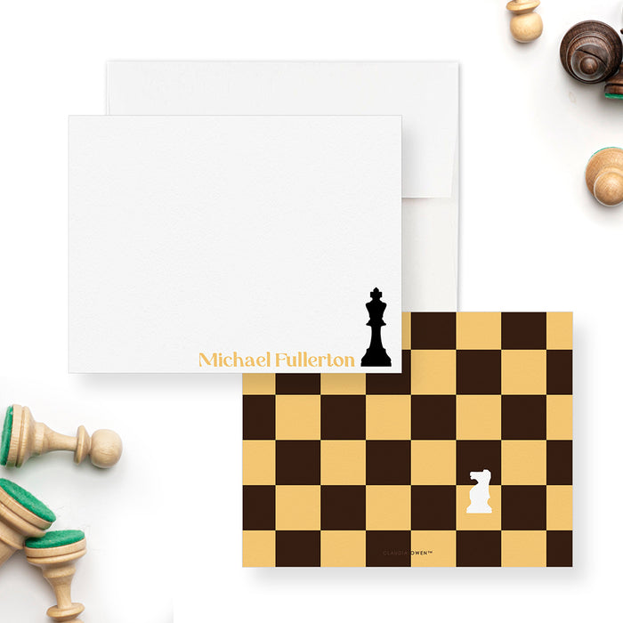 Chess note cards with a black king and printed gold name on the white front, and a gold and brown chessboard with a white knight on the back.