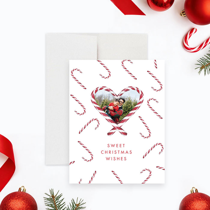 Personalized holiday greeting card featuring a family photo inside a heart-shaped candy cane frame with festive candy cane pattern, and sweet Christmas message-front
