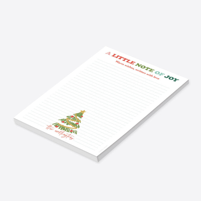 Personalized Christmas notepad featuring a hand-drawn Christmas tree, colorful holiday heading, lined writing space, and a custom family name-side