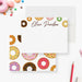 White personalized note card with colorful frosted donuts along the top, beside a matching donut-patterned back.