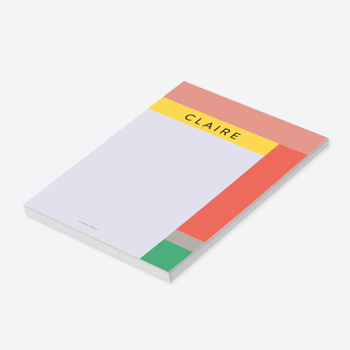 Personalized geometric notepad with a name, soft lavender writing area, and coral, yellow, blush, gray, and green color blocks-side