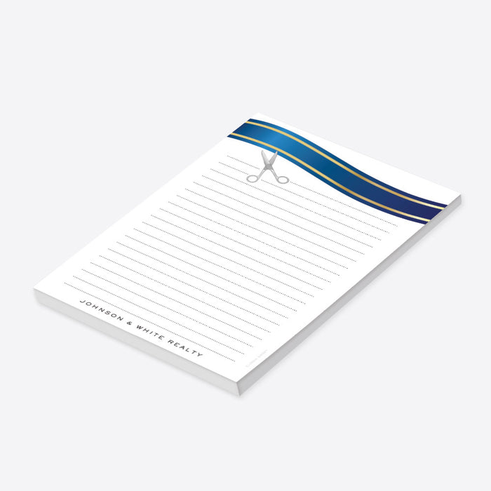 personalized ribbon cutting notepad with blue ribbon design, scissors illustration, lined writing area, and custom business name-side