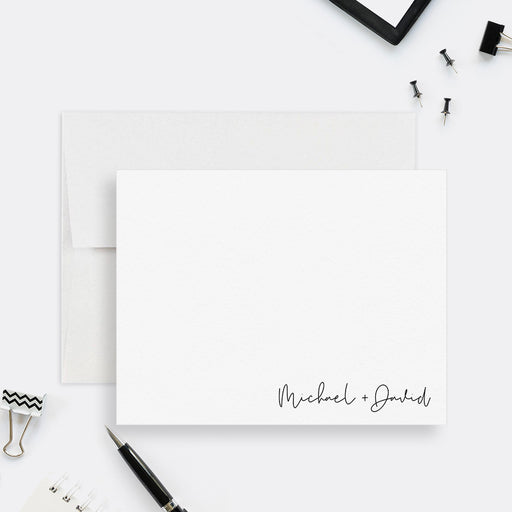 Minimalist personalized couples note card with two names in black script at the lower right, shown with a white envelope-front