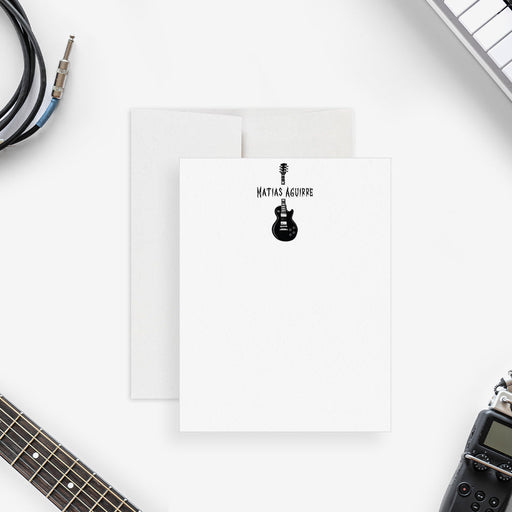 Personalized note card with a black electric guitar illustration and a personalized name, shown with a white envelope.