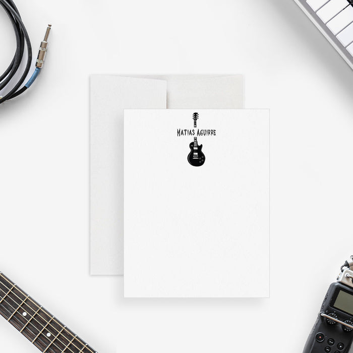 Personalized note card with a black electric guitar illustration and a personalized name, shown with a white envelope.