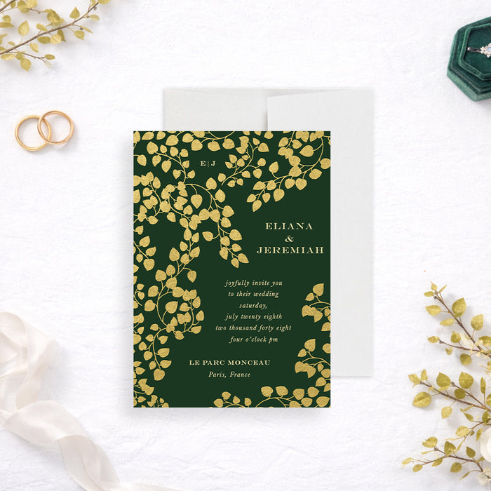 Personalized emerald green botanical wedding invitation with cascading gold-colored leaf vines, couple’s monogram, names and event details-front