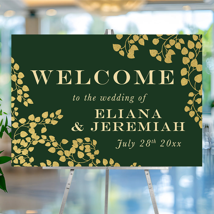 Personalized emerald green botanical wedding welcome sign with gold-colored leaf vines, custom couple’s names and wedding date
