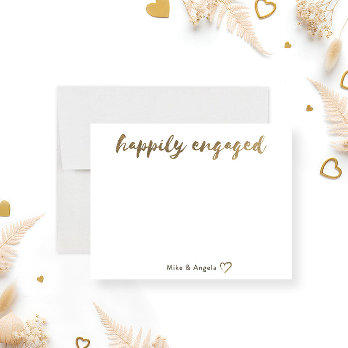 Front and back of personalized engagement note card with Happily Engaged script, couple’s names, beige back and gold heart accents-front