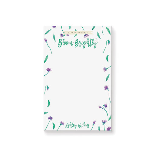Personalized floral notepad with purple flowers and green leaves, custom name stationery for garden party favors or gifts.