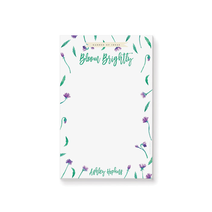 Personalized floral notepad with purple flowers and green leaves, custom name stationery for garden party favors or gifts.