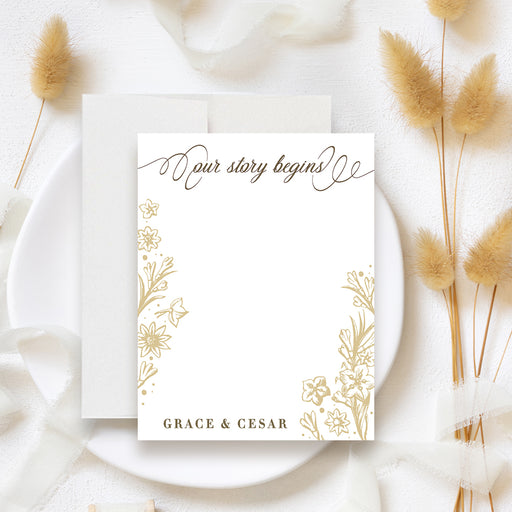 Personalized white and gold floral note card with “Our Story Begins” lettering, blank writing space and custom couple names-front