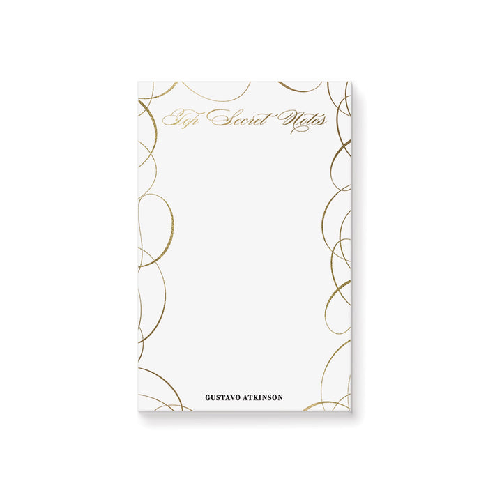 Personalized white notepad with gold swirl borders, elegant Secret Notes lettering, and a custom name at the bottom.