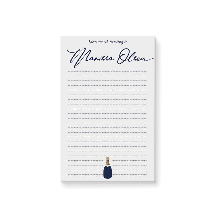 personalized navy champagne notepad with custom name in script, lined writing space, and small champagne bottle illustration