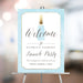 Personalized grand opening welcome sign with blue champagne bottle, pale blue border, business name, launch party wording and event date