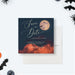 Halloween birthday save the date card with full moon, bats, dark sky, orange clouds, and personalized party details-front