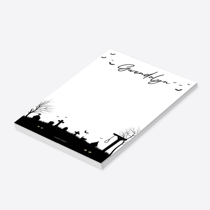 personalized Halloween notepad with spooky graveyard silhouette, bats, tombstones, custom name, and blank writing space-side
