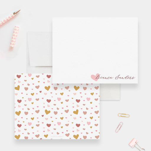 Personalized children's note cards with a pink heart beside the name on the white front and a pink and gold heart pattern on the reverse.