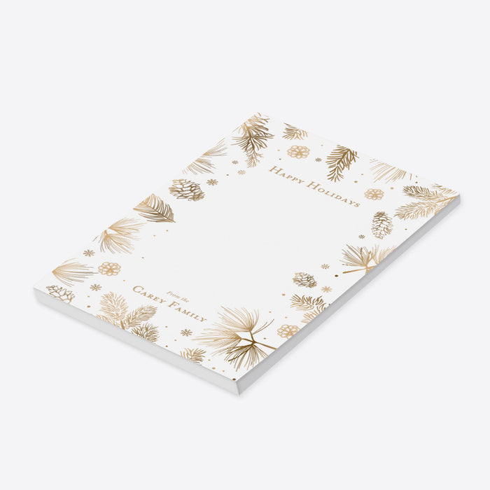 personalized holiday notepad with gold-toned pine branches, pinecones, snowflakes, festive border, and custom family name-side