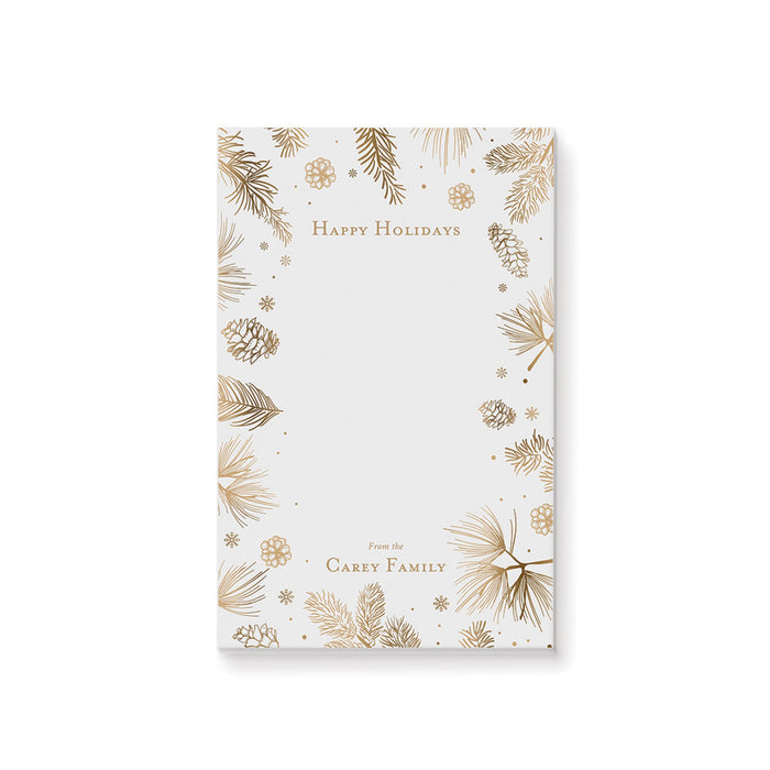 personalized holiday notepad with gold-toned pine branches, pinecones, snowflakes, festive border, and custom family name