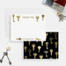 Front and back of personalized note cards with a decorative printed gold key design and personalized family name and a black back patterned with printed gold keys.