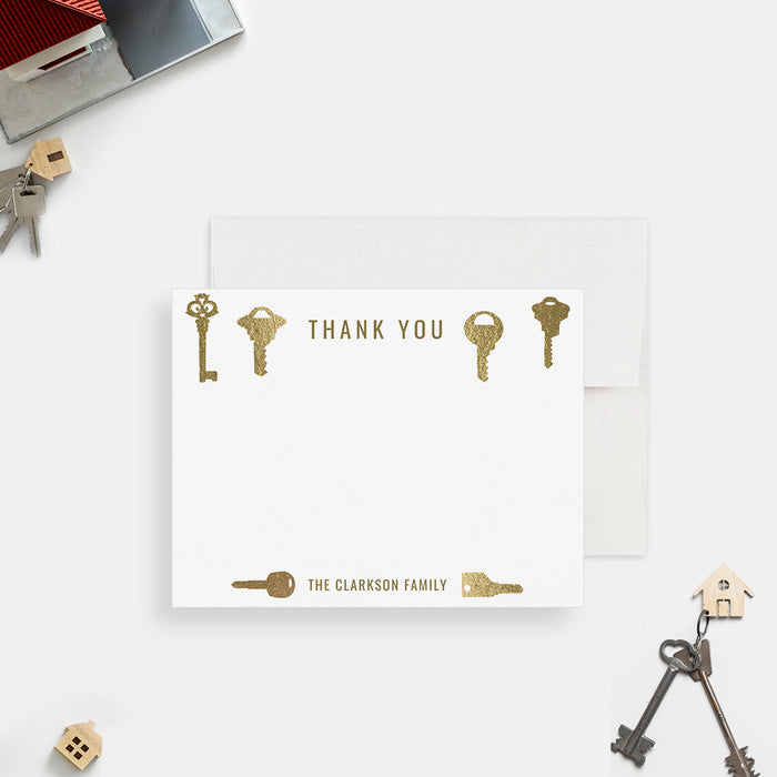 Personalized note card with a decorative printed gold key design and personalized family name, shown with a white envelope.