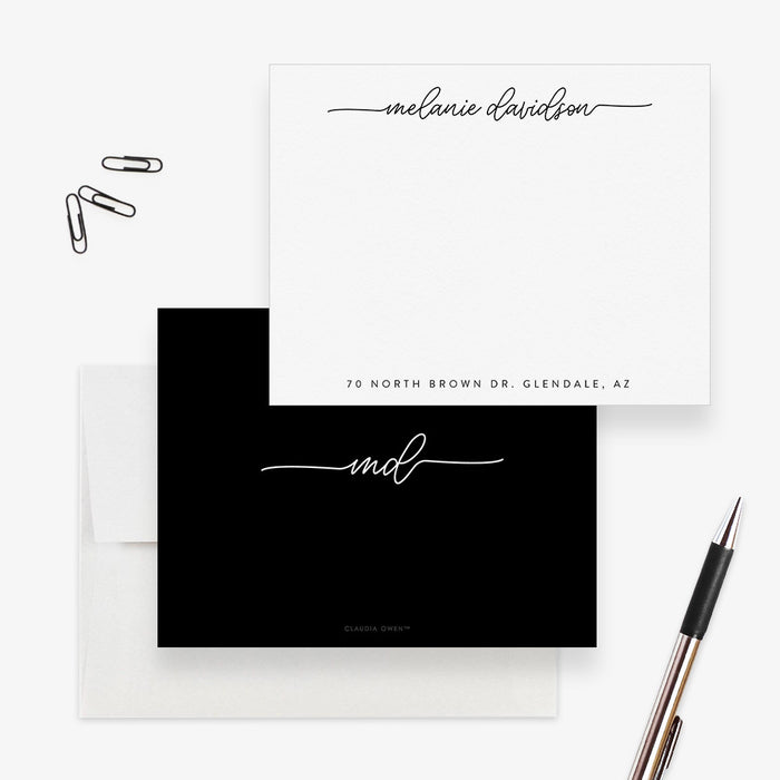 Black and white personalized note card with script name and address line, shown with a white envelope and pen-front-back