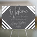 Personalized gray 40th birthday party welcome sign for men with honoree’s name, black-and-white diagonal stripes and modern script lettering