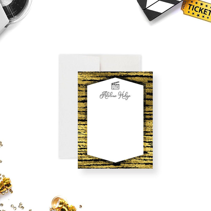 Personalized note card with a white writing panel with a clapperboard icon inside a printed black and gold striped border. Shown with a white envelope.