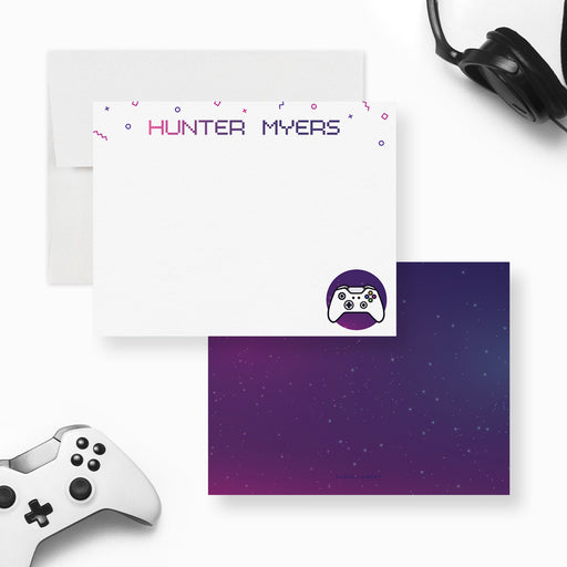 Personalized gamer note cards with colorful name lettering and a purple controller illustration on the white front and a purple starry reverse.