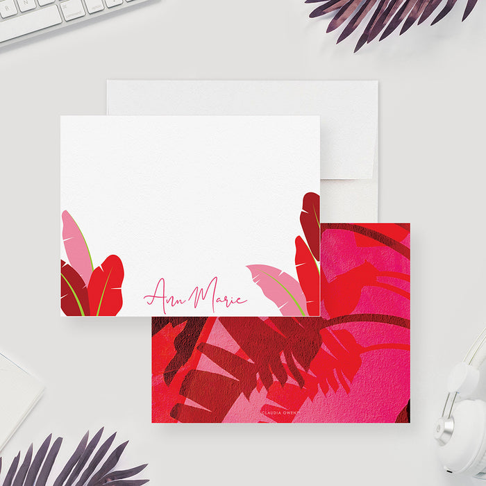 Personalized white note card with red and pink tropical leaf illustrations along the lower corners and a script name.