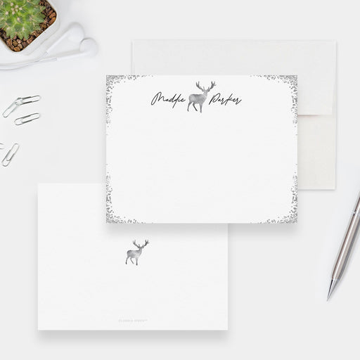 Personalized white note cards with a silver-colored deer outline, script name and decorative silver-colored border.