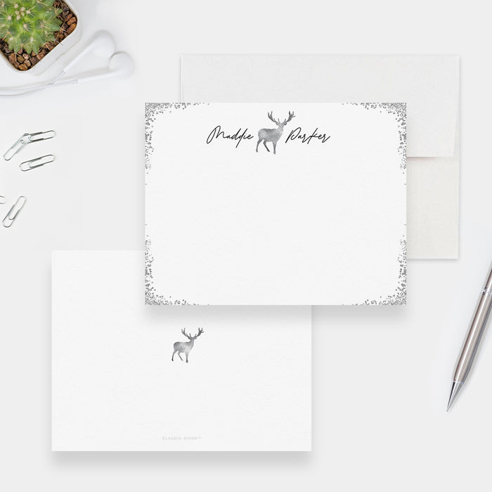 Personalized white note cards with a silver-colored deer outline, script name and decorative silver-colored border.