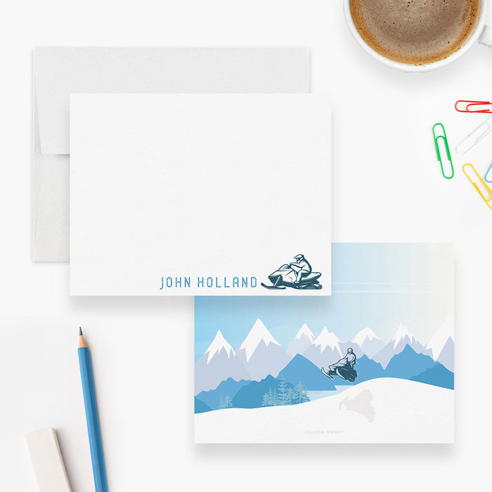 Front and back of personalized note cards with a snowmobile rider illustration and a personalized name and a blue snowy mountain scene on the back.