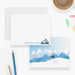 Front and back of personalized note cards with a snowmobile rider illustration and a personalized name and a blue snowy mountain scene on the back.
