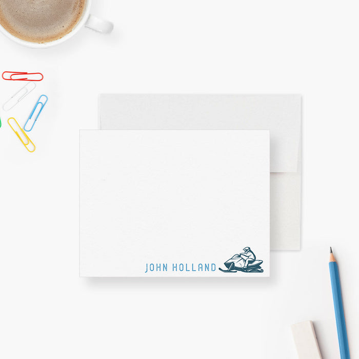 Personalized note card with a snowmobile rider illustration and a personalized name, shown with a white envelope.
