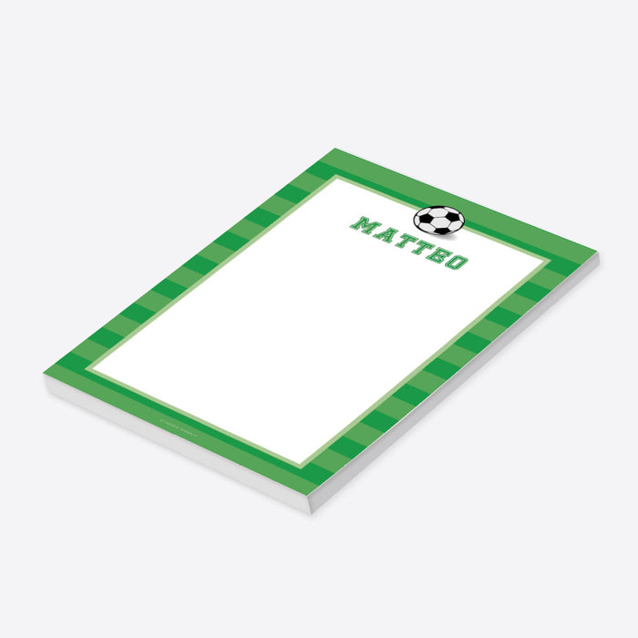Personalized soccer notepad with a black-and-white soccer ball, green striped border, custom name, and a large white writing area.