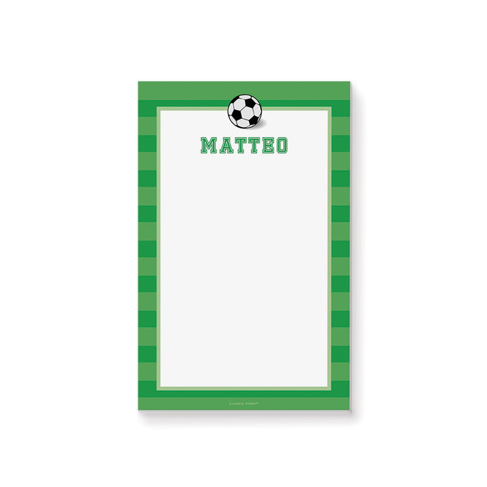 Personalized soccer notepad with a black-and-white soccer ball, green striped border, custom name, and a large white writing area.