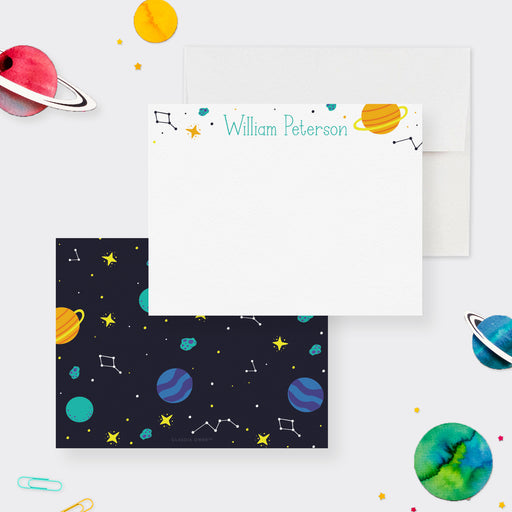 White personalized space note card with planets and stars, beside a dark back patterned with planets, constellations and meteors.
