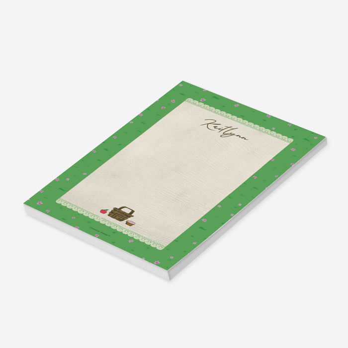 personalized spring picnic notepad with custom name, picnic basket illustration, lace border, green grass pattern, and tiny pink flowers-side