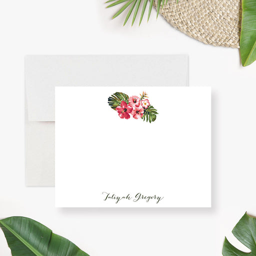Personalized note card with a white front with pink hibiscus flowers, green leaves, and a name in script. Shown with a white envelope.