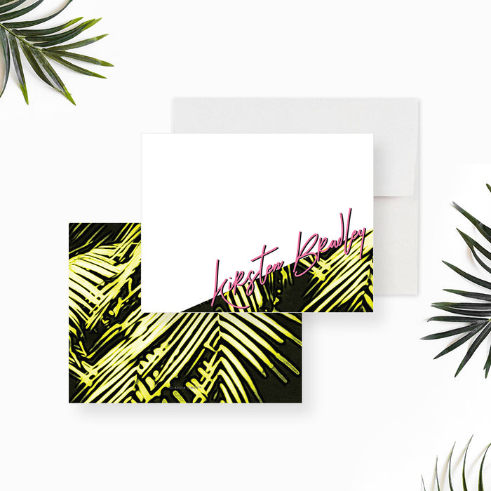 Personalized white note card with green palm leaf illustrations in the lower right corner and a pink script name.